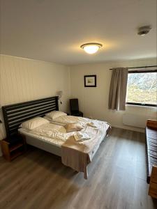 Schlafzimmer mit einem Bett und einem Fenster in der Unterkunft Christineborg Gjestehus Runde in Runde