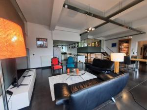 een woonkamer met een bank en een tafel bij Liège : superbe loft de caractère à 10' du centre in Luik