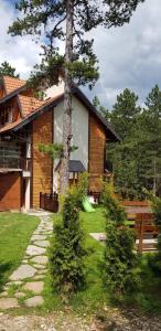 a house with a tree in front of it at Apartmani Sredojevic in Kaludjerske Bare