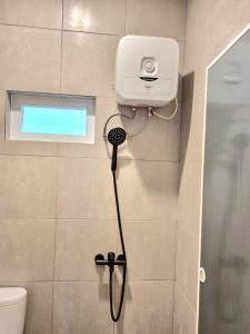 a shower in a bathroom with a camera on the wall at Zizi Homey Cemara Asri 302 in Pulauberayan Dadap