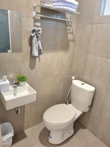 a bathroom with a white toilet and a sink at Zizi Homey 302 Cemara Asri in Pulauberayan Dadap