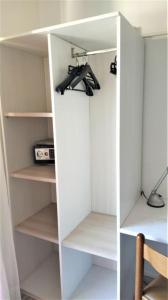 a white closet with someones shoes in it at Hotel Ciao Bed & Breakfast in Lignano Sabbiadoro