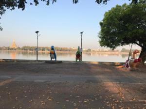a group of three statues sitting next to a body of water at Grace Hostel in Khon Kaen