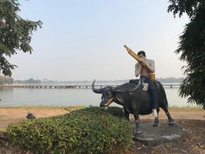 uma estátua de um homem montado num touro em Grace Hostel em Khon Kaen