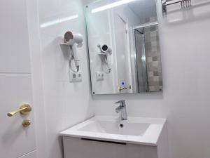 a white bathroom with a sink and a mirror at ONE PIECE Apartamento con patio in Alcobendas +11 photos