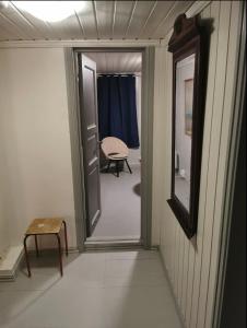 um corredor com uma porta que leva a um quarto em Sjarmerende historisk leilighet midt i Tromsø em Tromsø