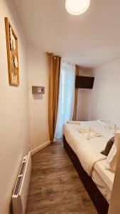 a hotel room with a bed and a window at HOTEL FORMIO in Paris