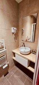 W łazience znajduje się umywalka i lustro. w obiekcie HOTEL FORMIO w Paryżu