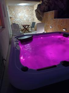 uma grande banheira roxa num quarto em Apartmani Blazevic em Omiš