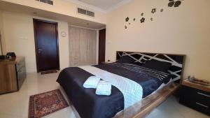 1 dormitorio con 1 cama grande y 2 toallas. en CITYSCAPE RETREAT, en Sharjah
