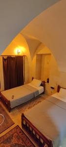 two beds in a room with an arched ceiling at Ktisis Butik Otel in Urfa