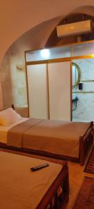 a bedroom with two beds and a table with a remote at Ktisis Butik Otel in Urfa