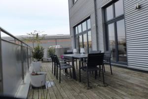 een terras met een tafel en stoelen bij Liège : superbe loft de caractère à 10' du centre in Luik