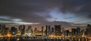 a city skyline at night with a city at Cityscape Retreat Apartment in Sharjah