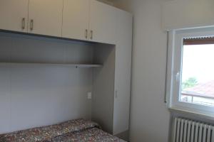 een kleine slaapkamer met een bed en een raam bij Ferienwohnung für 2 Personen 1 Kind ca 35 qm in Malcesine, Gardasee Ostufer Gardasee - b43578 in Malcesine