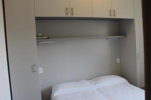 een kleine slaapkamer met een bed en witte kasten bij Ferienwohnung für 2 Personen 1 Kind ca 35 qm in Malcesine, Gardasee Ostufer Gardasee - b43578 in Malcesine