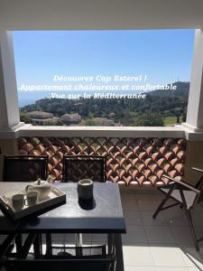 Una mesa y sillas en un balcón con vista. en Cap Esterel - Charmant T2 climatisé vue mer 4/5 pers - Piscine - Parking, en Agay - Saint Raphael