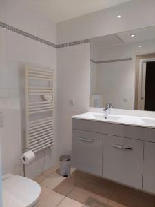 a white bathroom with a toilet and a sink at Maison Gamine mit privatem Pool in Cogolin