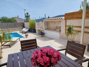 a patio with a table with pink flowers on it at Maison Gamine mit privatem Pool in Cogolin