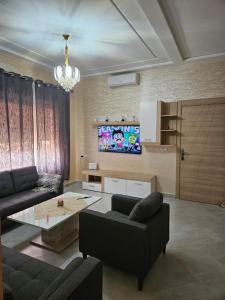 ein Wohnzimmer mit einem Sofa und einem Tisch in der Unterkunft Green house in Saidia 