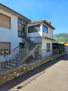 una casa blanca con escaleras y una valla en Guest House Fantaccini, en Pelago
