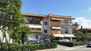a building with cars parked in a parking lot at Casa Vacanze Milosa in Terme Vigliatore
