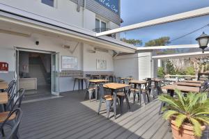 um restaurante com mesas e cadeiras num deque em Hotel du Cap em Capbreton