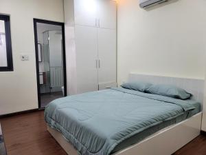 a bedroom with a bed and a white cabinet at LUCY HOTEL & APARTMENT in Ho Chi Minh City