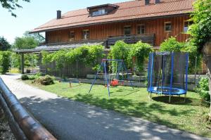 un patio con parque infantil frente a una casa en Ferienwohnung für 2 Personen 1 Kind ca 55 qm in St Oswald, Bayern Bayerischer Wald en Sankt Oswald