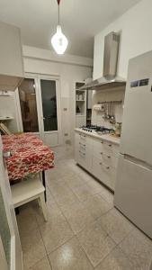 eine Küche mit einem Tisch und einem Kühlschrank in der Unterkunft casa vacanze Ugo e Betty in Sanremo