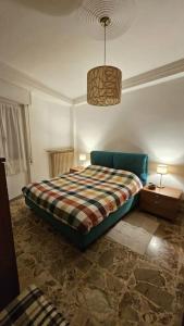 ein Schlafzimmer mit einem Bett mit einer karierten Decke in der Unterkunft casa vacanze Ugo e Betty in Sanremo