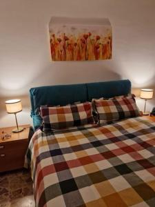 ein Schlafzimmer mit einem Bett mit zwei Lampen und einem Gemälde in der Unterkunft casa vacanze Ugo e Betty in Sanremo