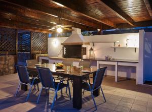 a dining room with a table and chairs and a kitchen at Ferienhaus in Vlycha Beach mit privatem Pool und herrlicher Aussicht in Líndos