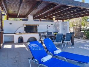 a patio with chairs and a table and a fireplace at Ferienhaus in Vlycha Beach mit privatem Pool und herrlicher Aussicht in Líndos