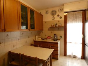 a kitchen with wooden cabinets and a table at Lily Rose House in Venice