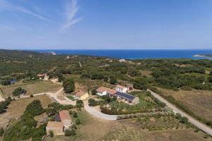 una vista aérea de una casa en una colina junto al océano en Ferienwohnung für 2 Personen ca 35 qm in Rena Majore, Sardinien Gallura en Aglientu