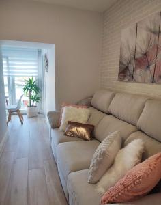 a living room with a couch with pillows on it at Vista al puerto. in Finisterre