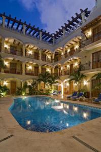 un gran edificio con una piscina en un patio en Hacienda Real del Caribe Hotel, en Playa del Carmen