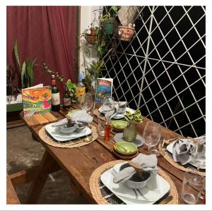 a wooden table with plates and wine glasses on it at Adella's Blue Mountain Coffee Farmstay in Kingston
