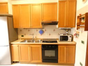 a kitchen with wooden cabinets and a sink and a microwave at Lily Rose House in Venice