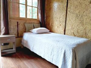 a bedroom with a white bed with a window at Cabaña El canto del Arriero in Oxapampa