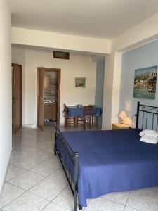 a bedroom with a blue bed and a table at Case Vacanza Trappetodavivere in Trappeto