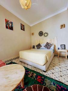 1 dormitorio con 1 cama grande y 1 mesa en Happy Marrakchy, en Marrakech