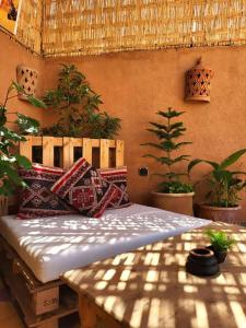 una cama con almohadas en una habitación con plantas en Happy Marrakchy, en Marrakech