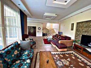 uma grande sala de estar com sofás e uma televisão em فيلا خاصة مفروشة بالكامل em Qaryat Shākūsh