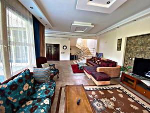 a large living room with couches and a tv at فيلا خاصة مفروشة بالكامل in Qaryat Shākūsh