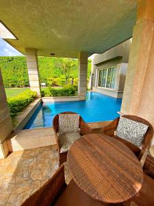 a swimming pool with a table and chairs in a house at فيلا خاصة مفروشة بالكامل in Qaryat Shākūsh