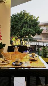 テルメ・ヴィリアトーレにあるCasa Vacanze Milosaのテーブル(食べ物とカップ付)