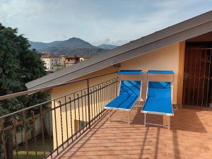 - deux chaises bleues assises sur le balcon d'une maison dans l'établissement LaPimpaLUINO, à Luino