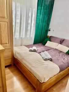 a bedroom with a bed with two towels on it at Przytulny apartament in Augustów
